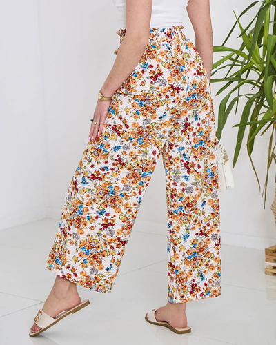Naiste valged palazzo püksid oranžide lilledega- Rõivad