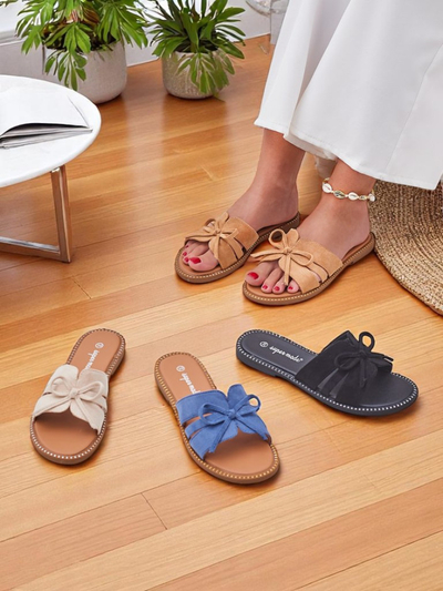 Women's flat slide sandals with a bow.