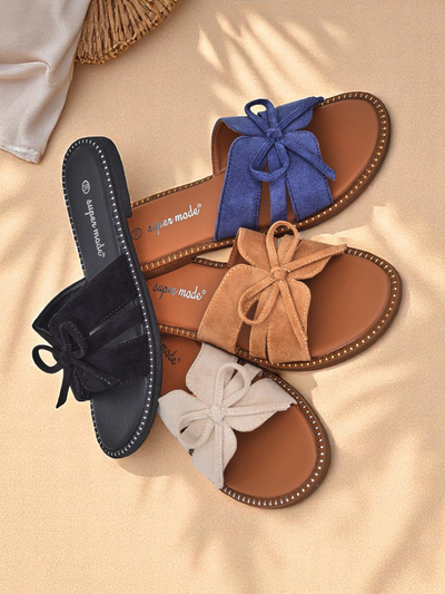 Women's flat slide sandals with a bow.